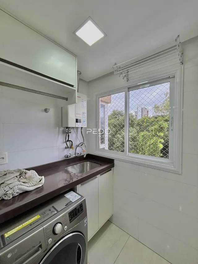 Vista da cozinha com armários e eletrodomésticos em Lajeado.