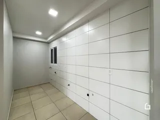 Hall de entrada com piso de cerâmica e paredes brancas.