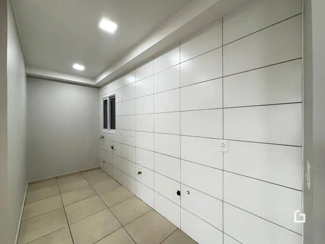 Hall de entrada com piso de cerâmica e paredes brancas.