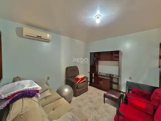 Sala de estar com sofá e móveis em um imóvel no Brasil.