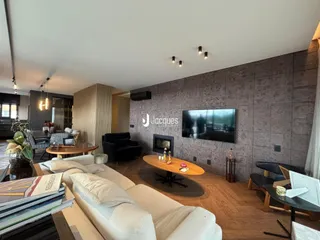 Sala de estar moderna com sofá e lareira em um imóvel no Brasil.