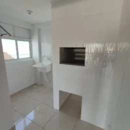 Foto de um corredor interno com paredes brancas e piso de cerâmica.