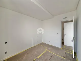 Vista interna de um cômodo vazio com piso de concreto.