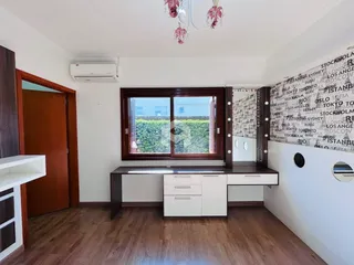 A sala de estar apresenta piso de madeira e uma grande janela com vista para o exterior.