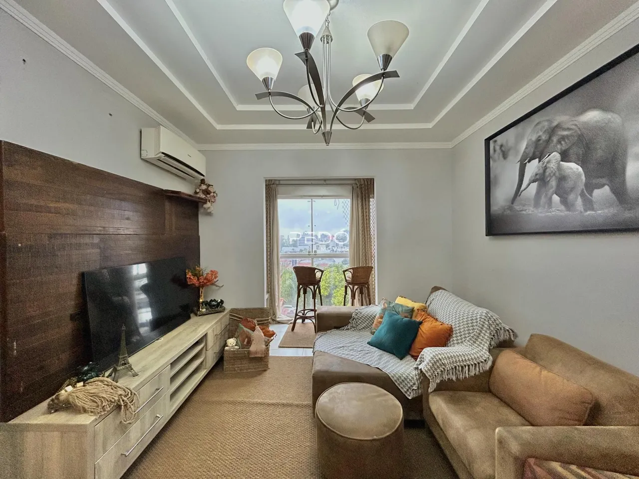Sala de estar com sofá e televisão em um apartamento.