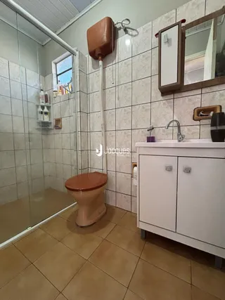 Foto de um banheiro com piso de cerâmica e box de vidro.