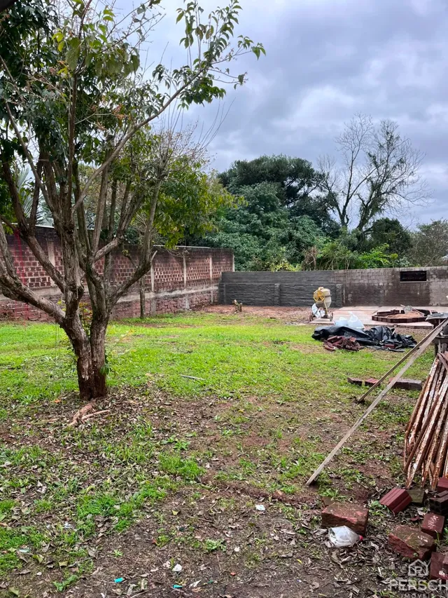 Uma área externa com grama e terra em um terreno.