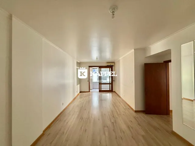Vista de um corredor interno com piso de madeira clara.