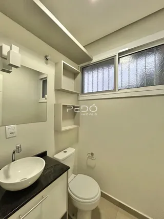 Foto de um banheiro interno com pia e vaso sanitário.