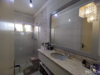 Foto de um banheiro com revestimento de azulejos brancos e bancada de mármore.