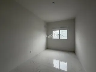 Interior de um cômodo com paredes brancas e piso claro.