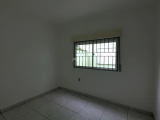Foto de um cômodo interno com paredes brancas e piso de cerâmica.