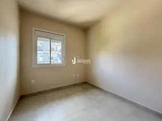 Ambiente interno de uma sala com piso de cerâmica e janela.