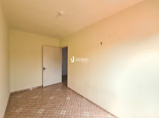 Vista interna de um corredor com paredes claras e piso de cerâmica.