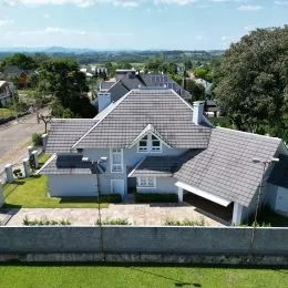 Fachada de uma casa com telhado de telhas cinzas em Lajeado, Brasil.