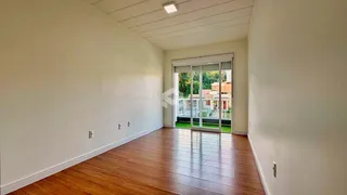 Sala de estar com piso de madeira e portas de vidro que dão para o exterior.