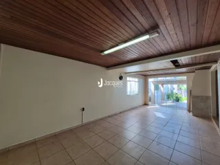 Vista interna de um corredor com piso de cerâmica e teto de madeira.