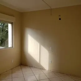 Ambiente interno com piso de cerâmica e janela iluminada.
