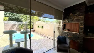 Sala de estar com porta de vidro que dá acesso a uma área externa com piscina.