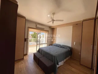 Quarto com piso de madeira e armários embutidos.