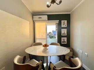 Uma mesa redonda de mármore branco com cadeiras está em uma sala de jantar.