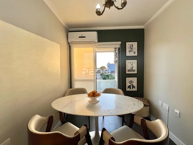 Uma mesa redonda de mármore branco com cadeiras está em uma sala de jantar.
