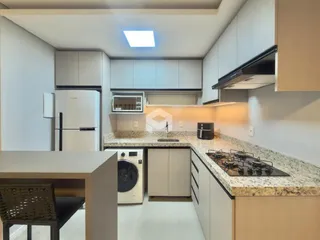 Foto de uma cozinha moderna com armários brancos e bancadas de granito.