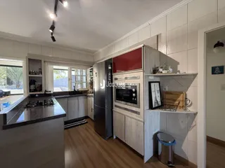 Foto de uma cozinha com armários e piso de madeira em um imóvel no Brasil.