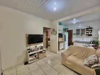 Uma sala de estar clara com sofá e móveis de madeira.