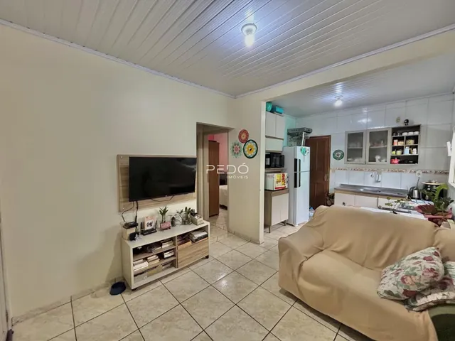 Uma sala de estar clara com sofá e móveis de madeira.