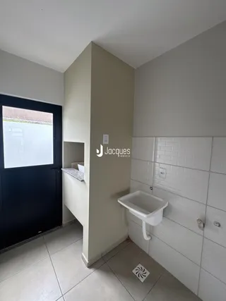 Imagem de um banheiro com pia e revestimento de azulejo branco.