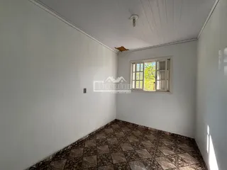 Foto de um cômodo interno com paredes brancas e piso de cerâmica.