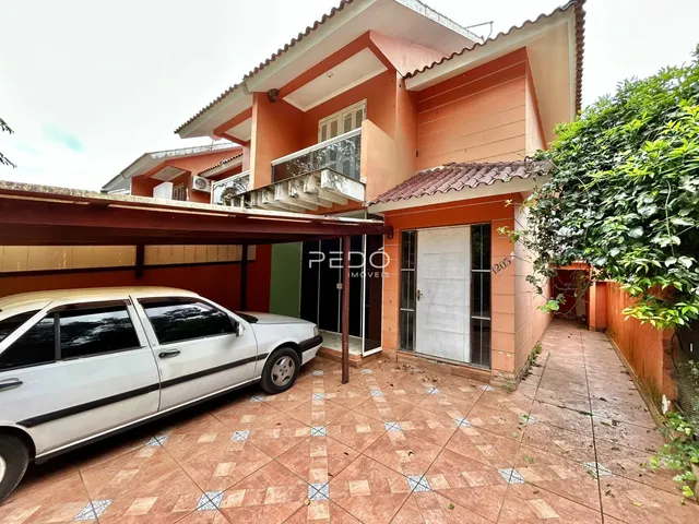 Foto da fachada de uma casa em Lajeado, Brasil, com um carro estacionado na frente.