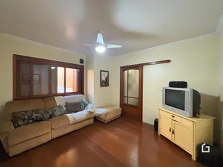Sala de estar com sofá e piso de madeira.