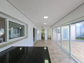 Vista interna de um ambiente com portas de vidro e piso de madeira.