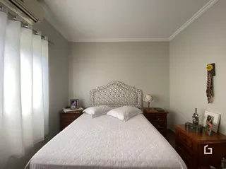 Quarto com cama e cortinas brancas.