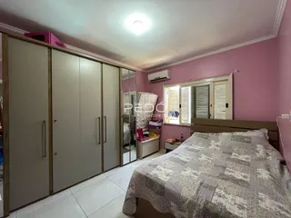 Quarto com armários embutidos e cama em um ambiente de cor rosa.