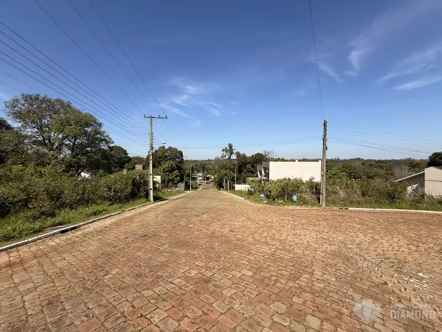 Uma rua pavimentada de tijolos se estende por uma área arborizada.