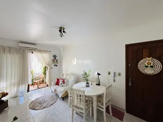 Sala de estar com sofá e mesa de jantar em ambiente claro.