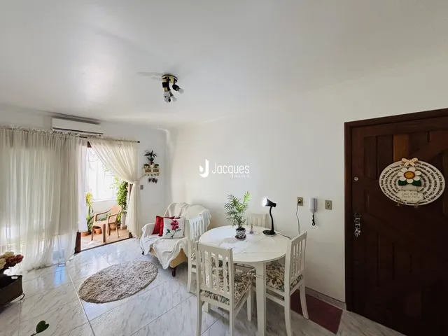 Sala de estar com sofá e mesa de jantar em ambiente claro.