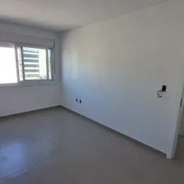 Vista interna de um cômodo com paredes brancas e piso claro.