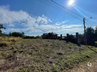 Vista externa de uma propriedade com vegetação seca no primeiro plano.