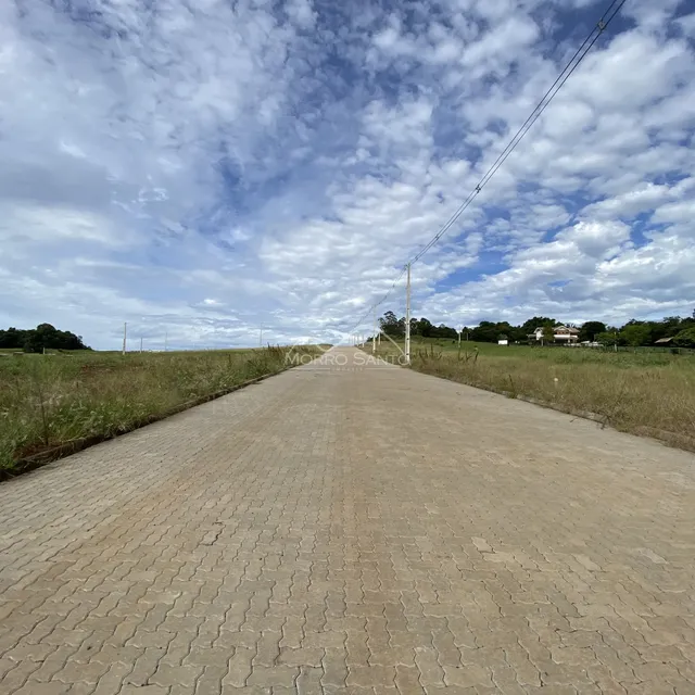 Uma estrada pavimentada se estende por um campo aberto sob um céu nublado.
