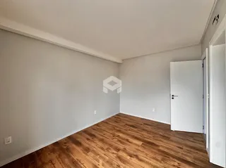 Imagem de um ambiente interno com piso de madeira clara.
