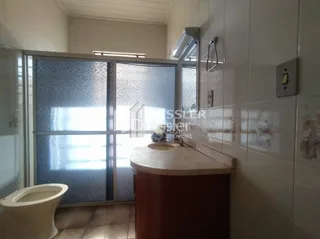 Foto de um banheiro interno com piso de madeira e azulejos brancos.