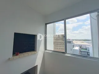 Parede interna com lareira e grande janela de vista.