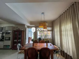 Foto de um ambiente interno com mesa de jantar de madeira e armários na residência.