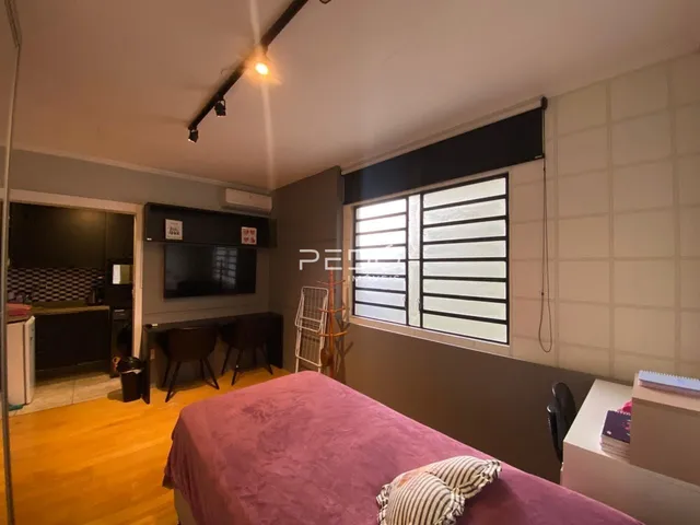 Quarto com cama e janela com persianas na sala.