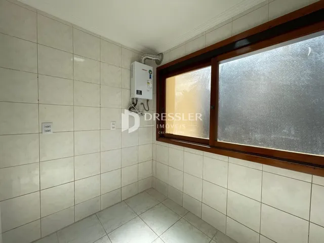 Interior de um corredor com paredes brancas e piso de cerâmica.