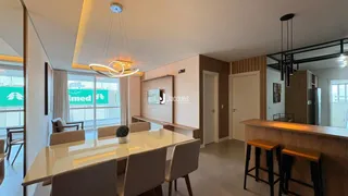 Sala de jantar com mesa de vidro e cadeiras em um apartamento.